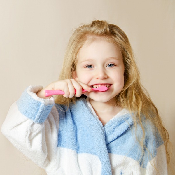 une jeune fille se brosser les dents