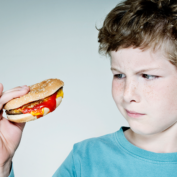 Un garçon regardant un hamburger