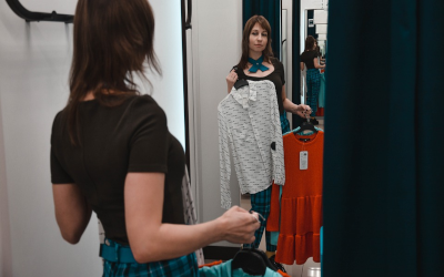 Femme tenant un vêtement dans un magasin. 
