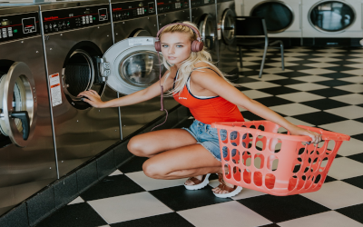 Femme mettant des vêtements dans une machine à laver