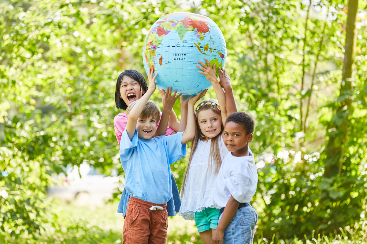 Des enfants tenant un globe à l’extérieur
