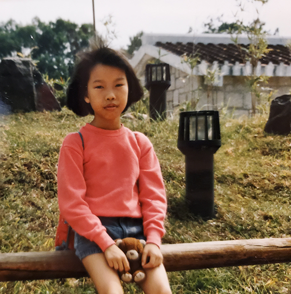 Child sitting on wooden fence.