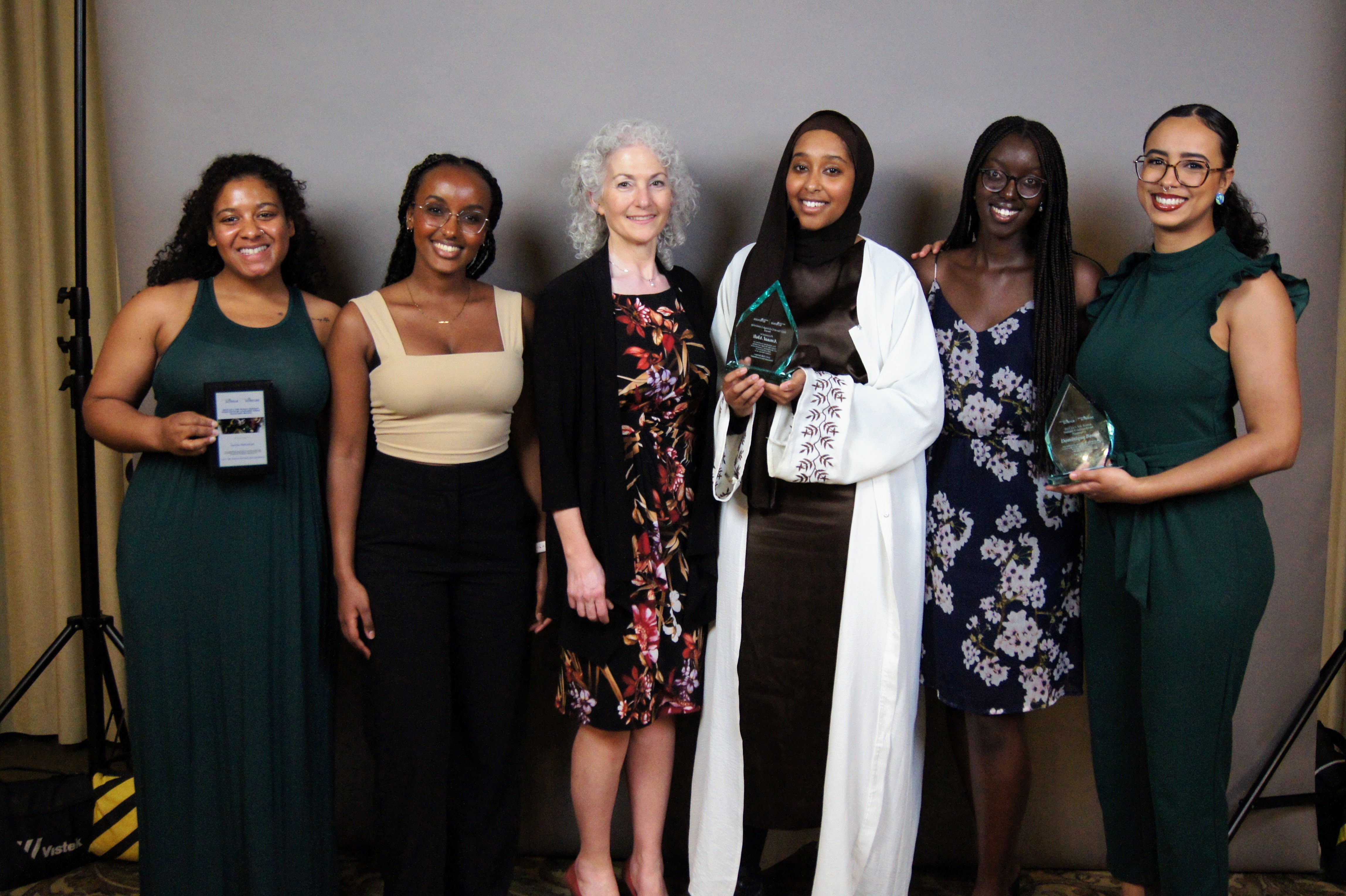 Amaal Abdi, Bonnie Schmidt and other volunteers in formal wear at banquet