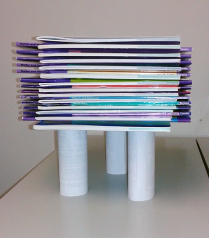 Une pile de 27 livres supportée par trois cylindres en papier