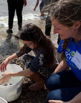 Une étudiante travaille avec une bénévole du programme de sensibilisation Parlons sciences lors d’une activité de libération de poissons