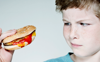 Un garçon regardant un hamburger