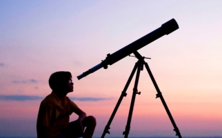 Garçon regardant le ciel nocturne dans un télescope