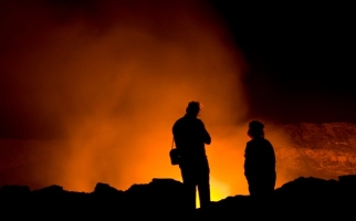 Des volcanologues examinant de la lave incandescente 