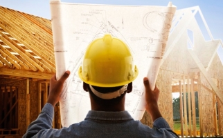 Travailleur de la construction avec des plans de maison