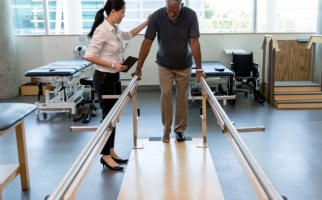  Physiotherapist helping a patient to walk