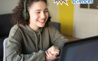 Une étudiante qui regarde son ordinateur en souriant. 