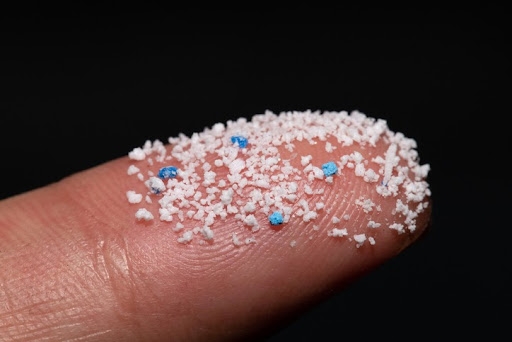 Des microplastiques sur un doigt