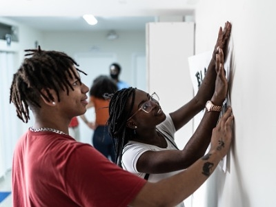 Students putting up a poster (FG Trade, iStockphoto)