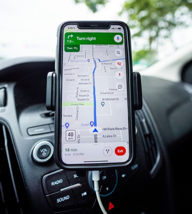 Smartphone on a car dashboard showing Google maps navigation