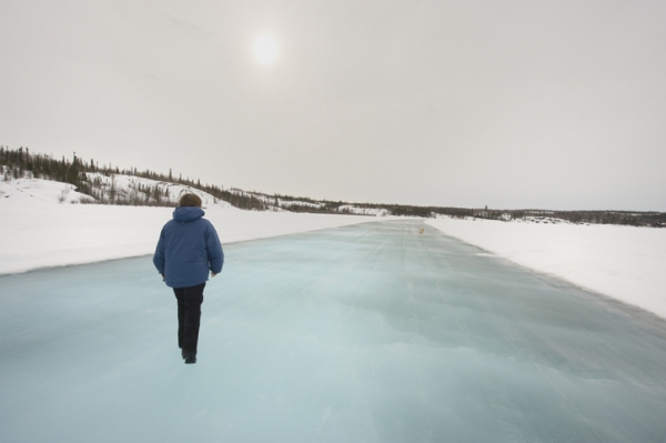 Une femme marche sur une route de glace près de Yellowknife