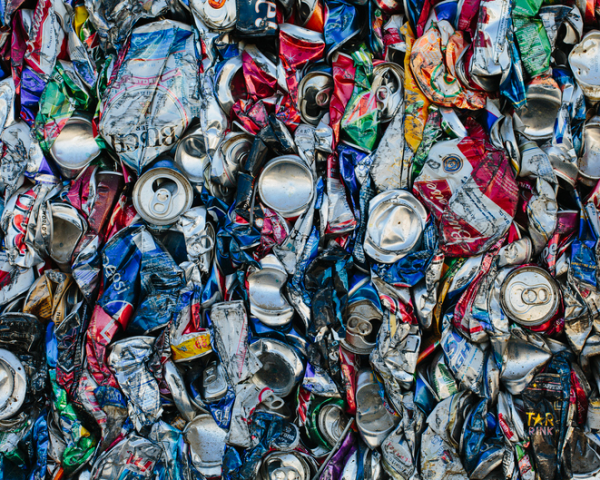 Shown is a colour photograph of hundreds of crushed drink cans.