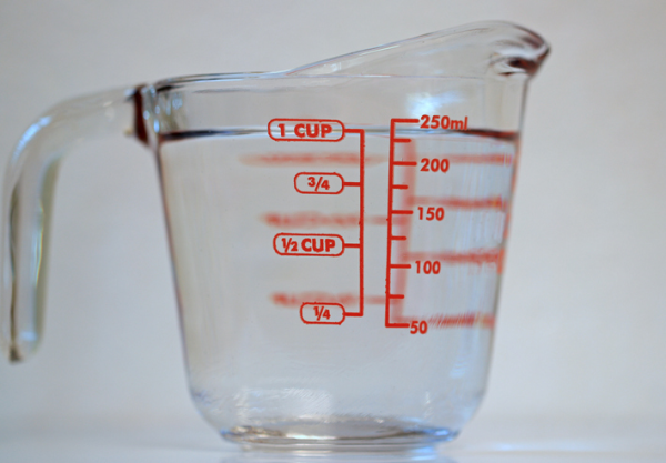 Shown is a colour photograph of liquid measuring cup marked in fractions of a cup and in milliliters.
