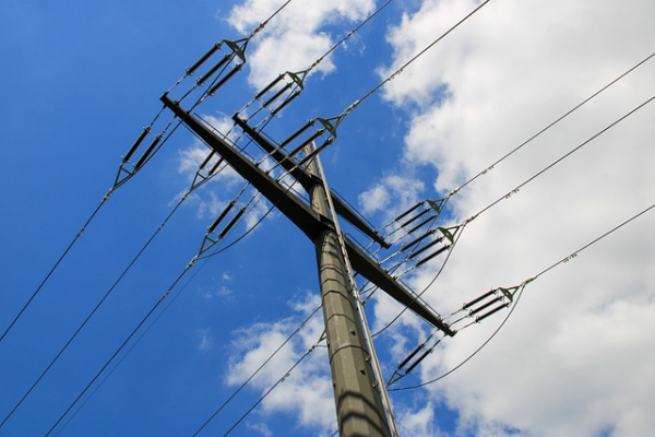 Shown is a colour photograph looking up a power pole.